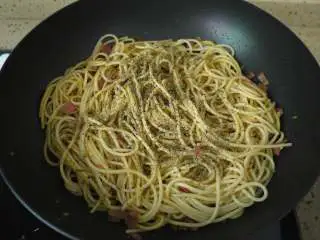 培根芝士意大利面,把煮好的意大利面放入,翻炒均匀,然后加入黑胡椒碎和欧芹碎。如果有新鲜的欧芹更好,味道更加清香。