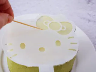 4寸KT猫抹茶慕斯蛋糕,再把白色的面片放在慕斯上,用牙签画出蝴蝶结、眼睛、鼻子、胡子的位置,再把巧克力按画好的位置摆放好即可