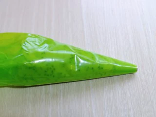 黑芝麻麻薯面包,将拌好的麻薯糊放入裱花袋，先装上圆的裱花嘴，不装也可以。(裱花袋最好使用橡胶的，面糊比较干，挤的时候需要用力，不然裱花袋容易破)