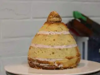 圣诞树枫糖戚风, 用蛋糕刀修整形状，如果不修整的话成品会显得比较圆胖。取一部分切下的边角料攥紧成团（圆锥形，抹少量奶油固定在顶部） 