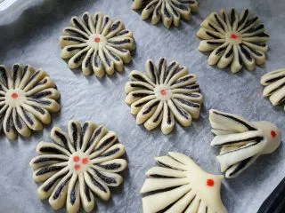 中式点心~玫瑰酥,所有的面胚制作完毕后,中间点上用红曲粉水加水稀释后的红点装饰。