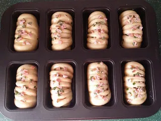 香葱火腿面包卷,出表面刷全蛋液，将前面预留的香葱火腿碎均匀地撒在面包坯表面