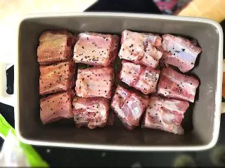 鲍汁焗小排淋酸甜洋葱酱,如图,把猪小排放在焗碗里,只摆一层就好。不要垒起来,因为要烤均匀。表面均匀撒少许盐和黑胡椒。然后放在烤箱里,180度烤10分钟。