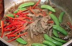 黑椒牛肉炒意粉,放入牛肉大火快炒至变色，然后倒入甜豆和红椒丝