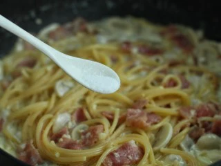 奶油蘑菇培根意面,调入适量的盐拌匀