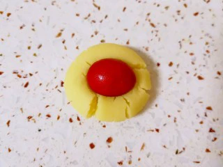 万圣节蜘蛛饼干, 取一个小圆球按扁，用巧克力豆在中间压一个小窝，取出巧克力豆。