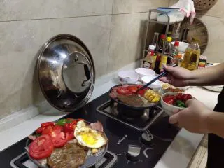 西餐菲力牛排,小铁锅盘加热后，加入少许橄榄油，放入已切好的洋葱翻炒2-3分钟后，放入煎好的牛排，鸡蛋，培根金针菇，放入提前炒好的辣椒火煺，再放入番茄，再放入牛排的同时浇上柠檬汁在牛排上，继续煎制1分钟，到8成熟的时候起锅，放入老抽调制好的热干面或意面，最后浇上加热后的黑胡椒酱汁就完成了