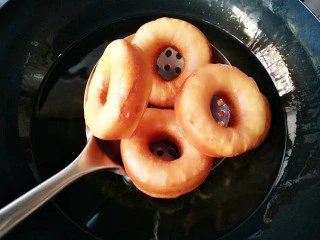 巧克力甜甜圈,炸的过程中,可以视情况翻面,炸至两面金黄后即可沥油捞出。