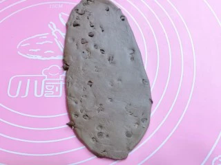 懒人必做~巧克力贝果,取一块醒发好的面团,用擀面杖擀成椭圆形。