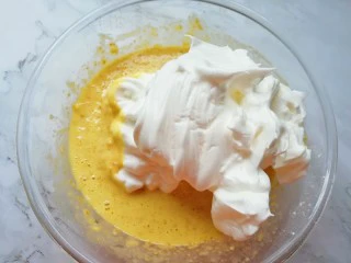 亚麻籽戚风蛋糕,打发好的蛋白分成三份,取中间的三分之一加入到亚麻籽蛋黄糊里面,用硅胶刮刀采用切拌和翻拌的方法混合均匀。