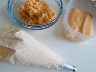 咸蛋黄肉松盒子蛋糕,咸蛋黄奶油装进裱花袋里，肉松准备好，蛋糕切成小块，可以根据自己的盒子的大小去切，我用的小盒子，如果用大盒子，奶油和肉松的量都要增加哦。