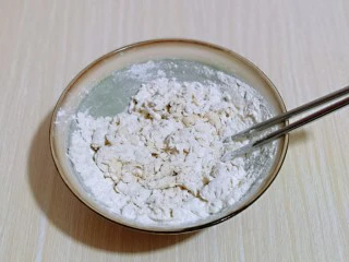 披萨新吃法~奥尔良鸡丁披萨,分次加入温水,一边加温水,一边用筷子搅拌成絮状。