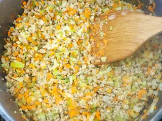 意大利肉酱意粉,锅内放入35ml橄榄油，下入牛肉粒煸炒。煸炒变色后放入胡萝卜、芹菜、洋葱一起煸炒。