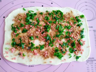 手撕海苔肉松面包,撒上肉松、火腿丁、小葱。
