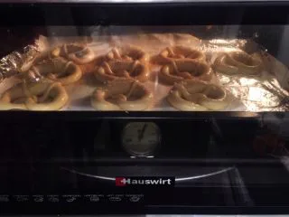 危险与美味并存一一德国碱水包,将普雷结放入烤箱，朝烤箱喷洒一些蒸汽，上下火15－20分钟（变成棕红色）