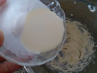 巧克力豆曲奇,把淡奶油分三次加入到黄油里,用电动打蛋器打发黄油。