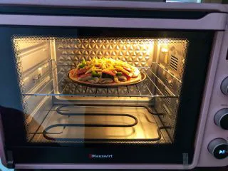 蔬菜火腿披萨,烤箱上下火185度预热好，把披萨放中层15分钟左右！(具体温度和时间根据自己家烤箱脾气。)