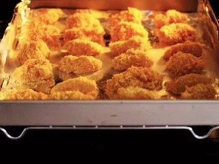 少油减脂的劲爆鸡米花,烤箱提前预热后，把烤盘入烤箱的中层。