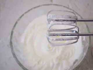 酸奶舒芙蕾蛋糕,用电动打蛋器打发至硬性发泡,就是提起打蛋器时有小尖角即可