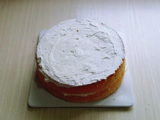 双层奶油蛋糕,把另一片盖上，再涂抹上奶油，把6寸的放在上面，抹上奶油。