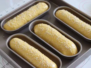 胡萝卜热狗面包,做营养美味早餐,放入发酵箱或者是环境35度左右的环境中,发酵大约1.5倍大。取出后刷一层薄薄的蛋液,并撒上白芝麻。