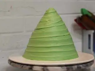 圣诞树枫糖戚风, 一边用抹刀轻贴奶油表面，一边转动裱花台，旋转向上移动抹刀，做出螺旋状奶油纹路 