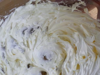 柠檬糖霜磅蛋糕,打盆裡加入室温软化的奶油跟盐，用中速打约四分鐘，打发的奶油顏色会变白、质地更膨鬆，再用刮勺把盆边的奶油都集中在一起