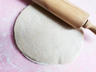 手抓饼蝴蝶酥,用擀面杖将手抓饼擀薄至1.5倍大,