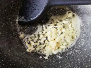 南瓜香肠意面,把锅洗净,放入适量黄油融化后放入切好的蒜瓣爆香