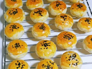 椰香桂花豆沙酥,烤好后戴上隔热手套取出烤盘，将椰香桂花豆馅酥摆放在烤网上，晾凉。