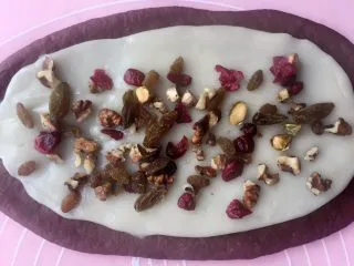 可可麻薯软欧包,面团擀薄 铺上同时擀好的麻薯 撒上适量的果干 PS:操作麻薯的时候戴一次性手套,砧板上,擀面杖上铺上裹上保鲜膜,可以更好的操作;