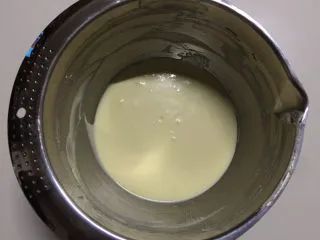 百香果冻芝士蛋糕,加入50克纯牛奶,用刮刀搅拌均