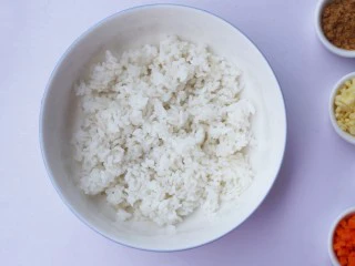 西兰花肉松芝士饭团,剩米饭倒入大碗中拌匀。