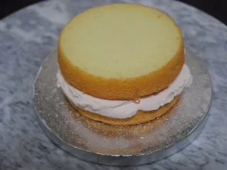 巧克力淋面蛋糕,放一片蛋糕片在底座上,抹上淡奶油,加入蜜豆,抹平后盖上一层蛋糕片