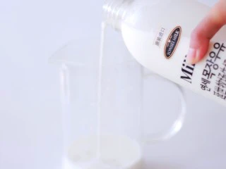 承味延世牛奶芒果布丁,撕开封口贴，把牛奶倒入量杯中