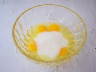 柠檬玛德琳蛋糕,鸡蛋打入容器中，一次性加入全部的白糖，用手动打蛋器搅拌至白糖融化