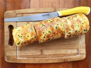 香葱肉松面包卷,打开油纸，把卷好的肉松卷切开。 