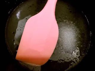 海苔肉松小贝,碗里加入清水,白糖15克,玉米油搅拌均匀至砂糖融化