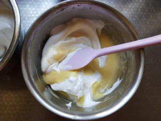 奶酪戚风纸杯,取三分之一蛋白加入面糊中翻拌均匀