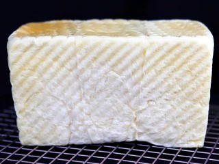 超绵软吐司(一次发酵),烤好的吐司立即取出,轻磕模具倒出放在凉架上放量。