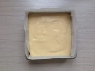 超柔软的棉花蛋糕,拌好的蛋糕糊倒入到铺了油纸的,18CM方型模具里。震动一下烤盘,使蛋糕糊里的大气泡震出来。