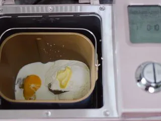 奶香小花朵馒头,把所有的称重食材全部倒入面包桶里，启动面包机的和面程序开始和面。