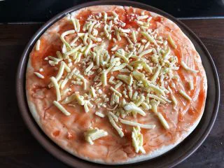 蔬菜火腿披萨,铺一层马苏里拉芝士。