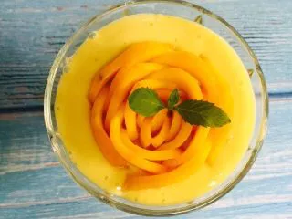 芒果香蕉奶昔,将芒果花轻轻放入杯子，薄荷叶装饰