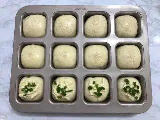 一次发酵餐包,取出烤盘，在面包表面刷上一层蛋液，撒上适量白芝麻装饰。也可以放上芝士、香葱、沙拉酱。