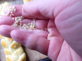 一发的淡奶油辫子面包,趁面包表面有一点潮湿时，快速的撒上芝麻。