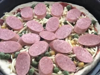 意式烤肠披萨,再放一层芝士后，放入烤肠。