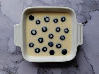 爆浆蓝莓蛋糕,将蛋糕液过筛入烤碗内（过筛是为了让蛋糕糊更细腻），然后放上蓝莓！ 烤箱185度预热10分钟后，放入烤碗，烤箱185度上下火中层烤27分型