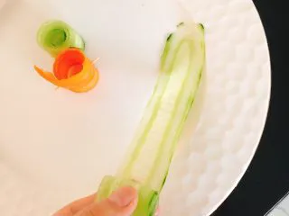 白灼沙拉三文鱼-西餐、年夜饭,从薄片一端慢慢卷起，卷成一个圆柱体摆盘，胡萝卜片卷好后无法自己黏连，需用牙签固定。