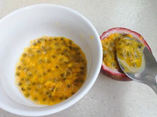 百变水果 蝶豆花蛋糕卷.百香果蓝莓馅,取两个百香果拿勺取出百香果汁,把子滤掉,喜欢籽的可以留下。